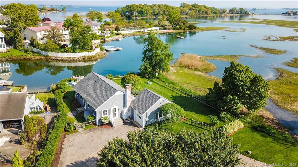 an aerial view of residential houses with outdoor space and lake view