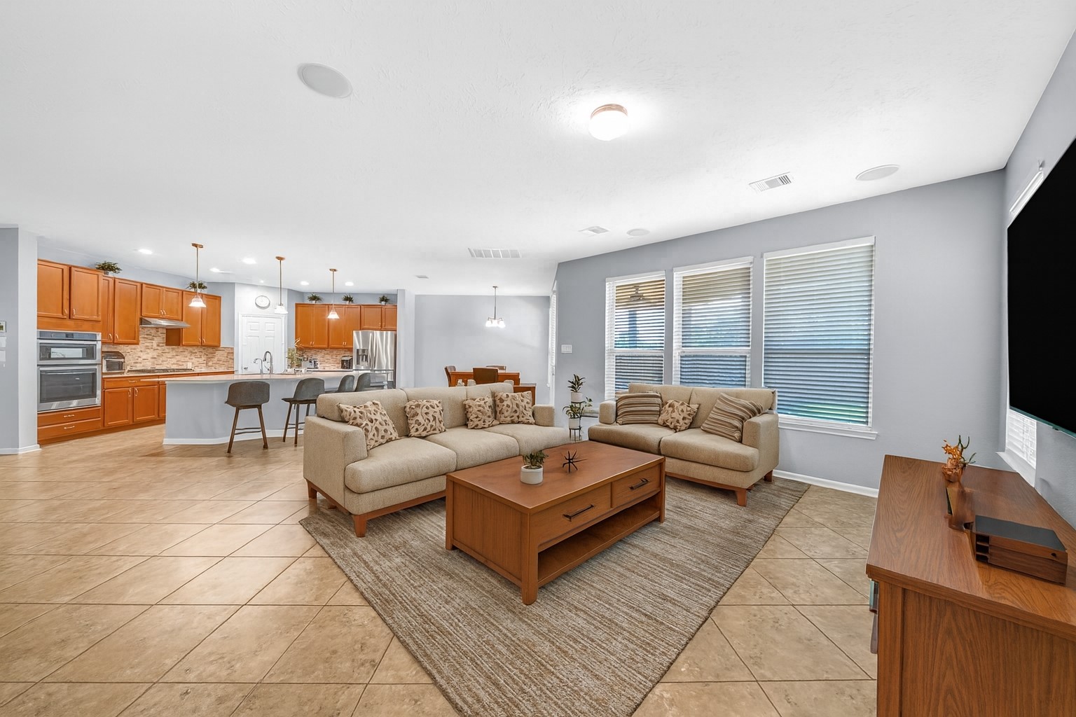 20703 Fawn Timber Trail Humble, TX 77346 - Photo 10 of 35 a living room with furniture a flat screen tv and a floor to ceiling window