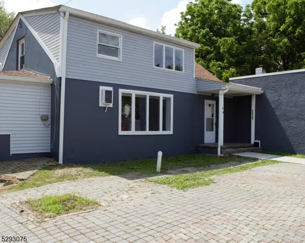 a view of a house with a yard and large tree