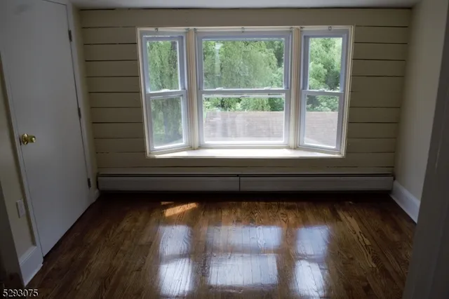 a view of a room with wooden floor and a window