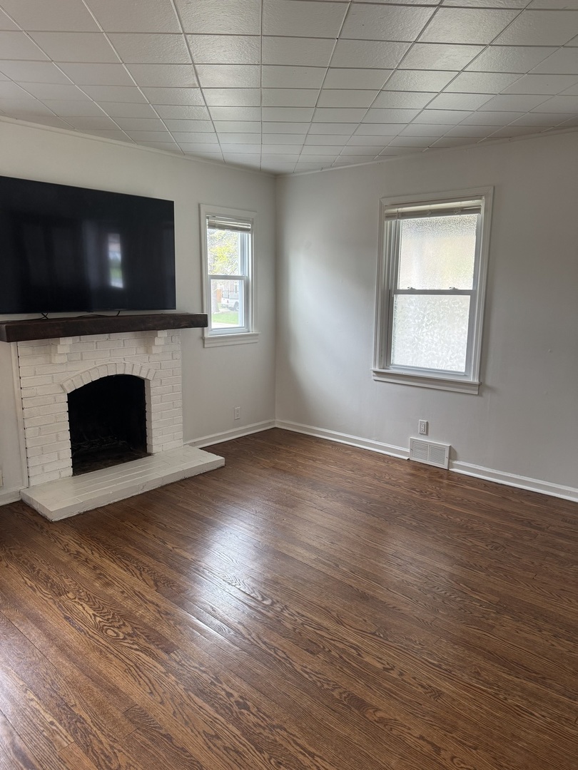 197 6th Street Wheeling, IL 60090 - Photo 43 of 51 an empty room with windows fireplace and wooden floor