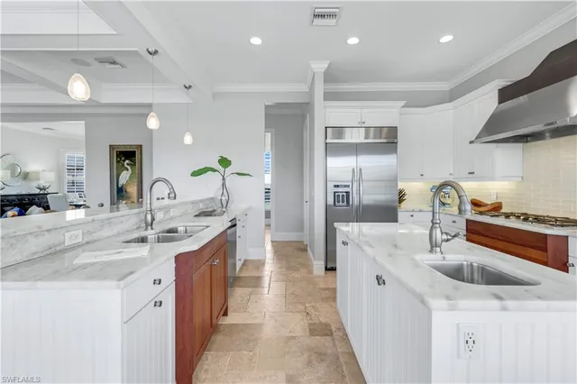 a kitchen with granite countertop a stove a sink a dining table and chairs