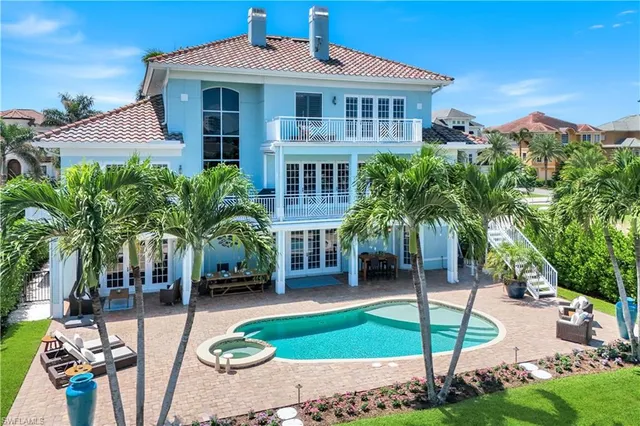 a front view of a house with swimming pool and furniture