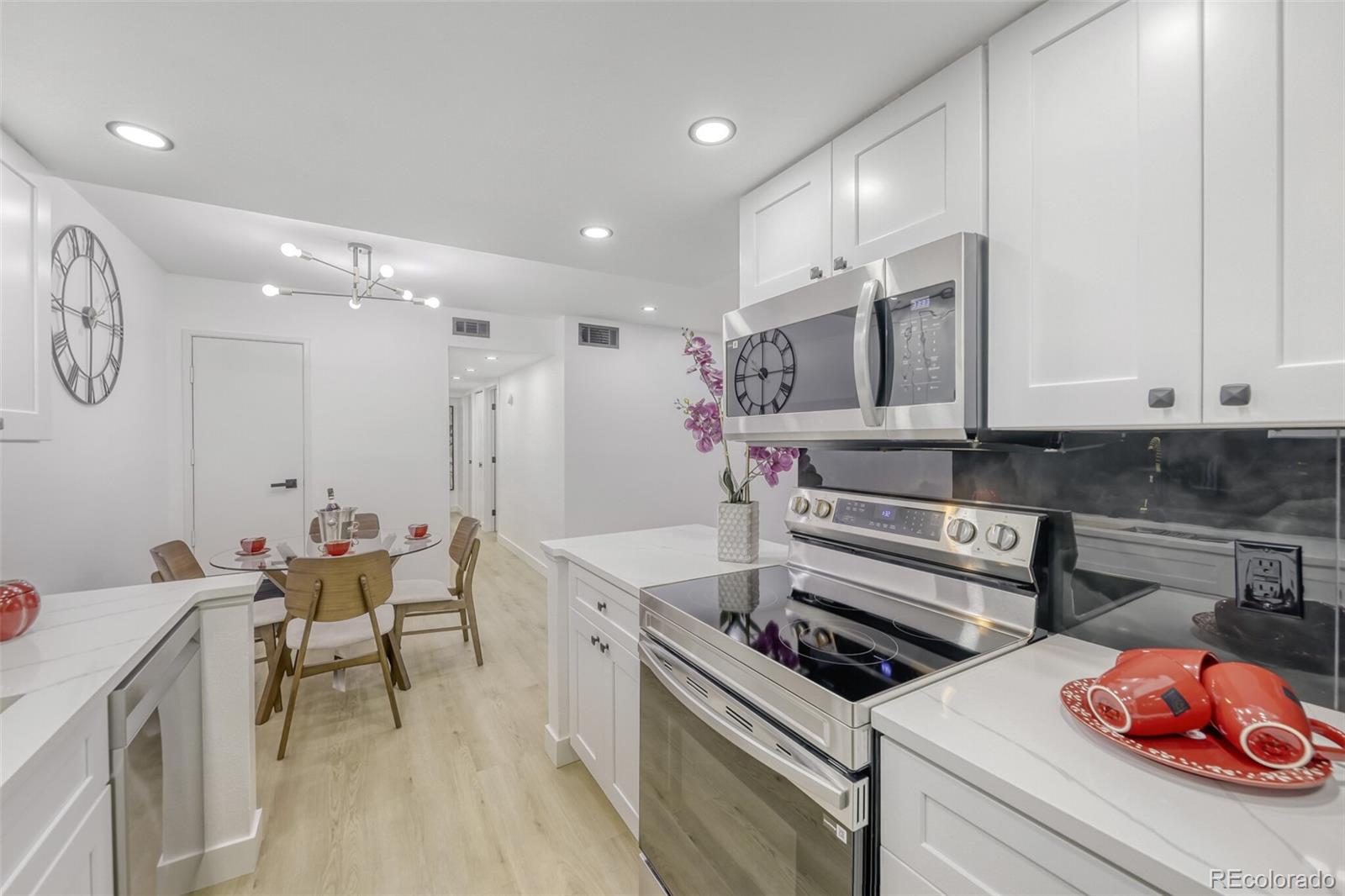 4400 South Quebec Street, Unit 106W Denver, CO 80237 - Photo 11 of 17 a kitchen that has a lot of white cabinets and stainless steel appliances