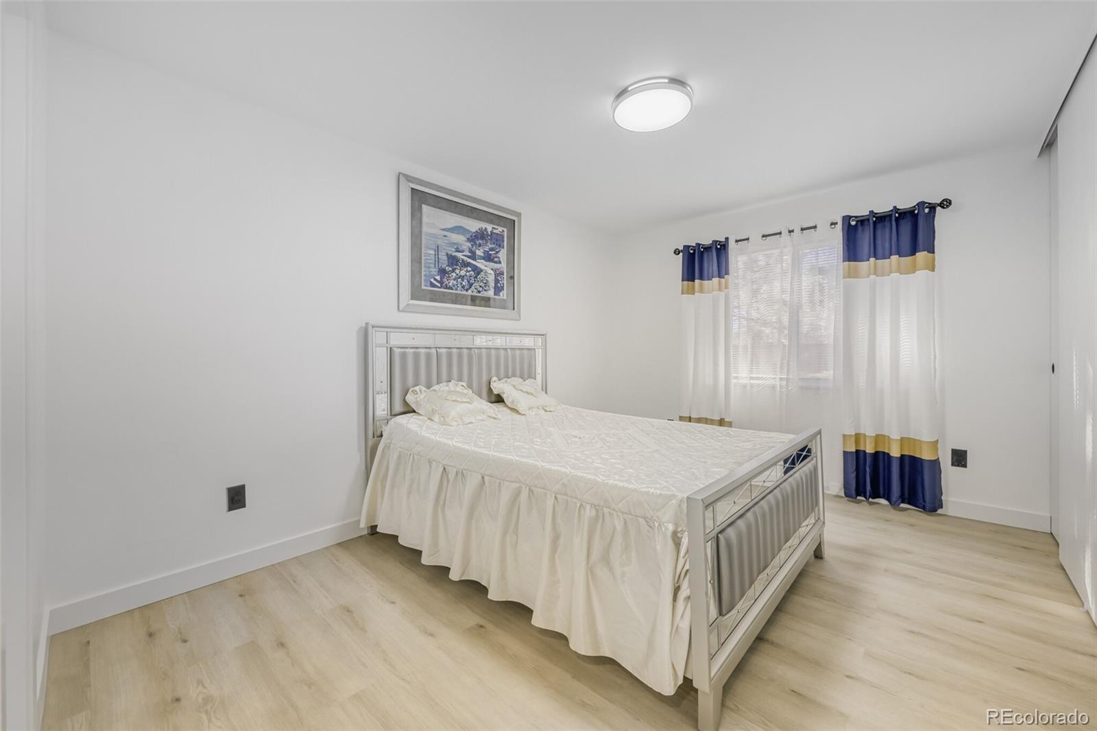 4400 South Quebec Street, Unit 106W Denver, CO 80237 - Photo 13 of 17 a bedroom with a bed and a table