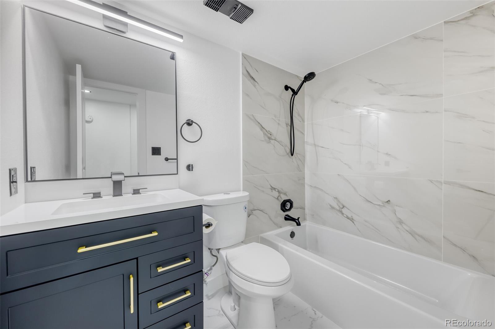 4400 South Quebec Street, Unit 106W Denver, CO 80237 - Photo 15 of 17 a bathroom with a double vanity sink toilet mirror and bathtub