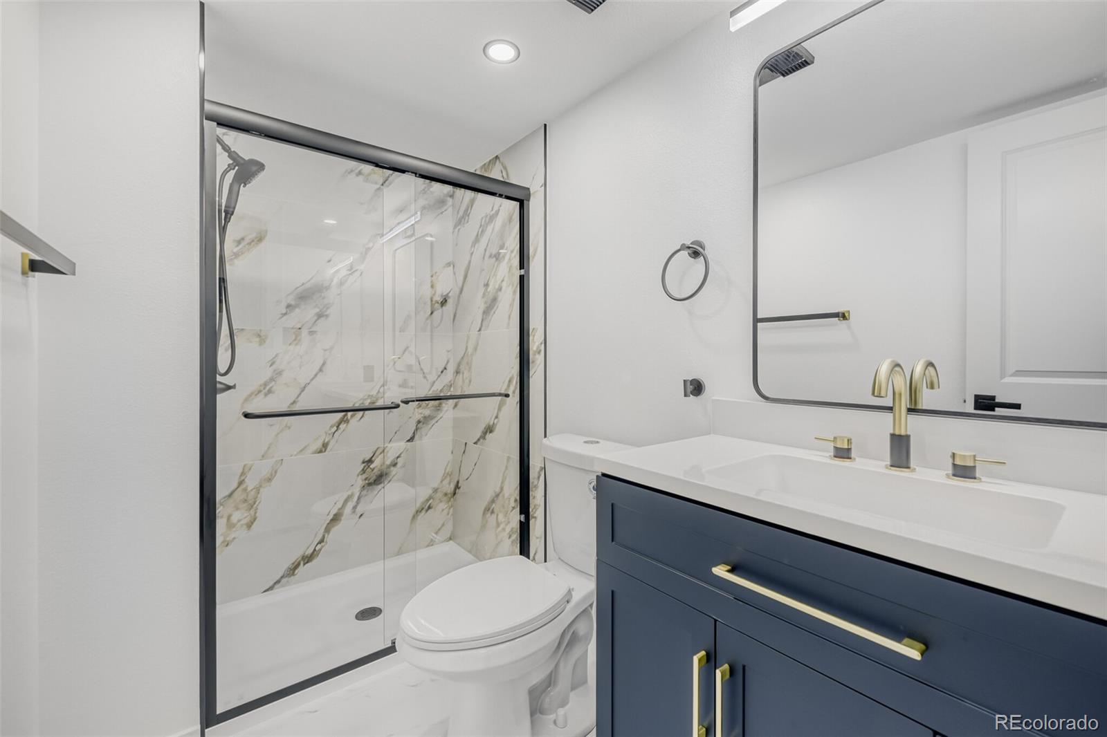 4400 South Quebec Street, Unit 106W Denver, CO 80237 - Photo 16 of 17 a bathroom with a shower sink vanity mirror and toilet