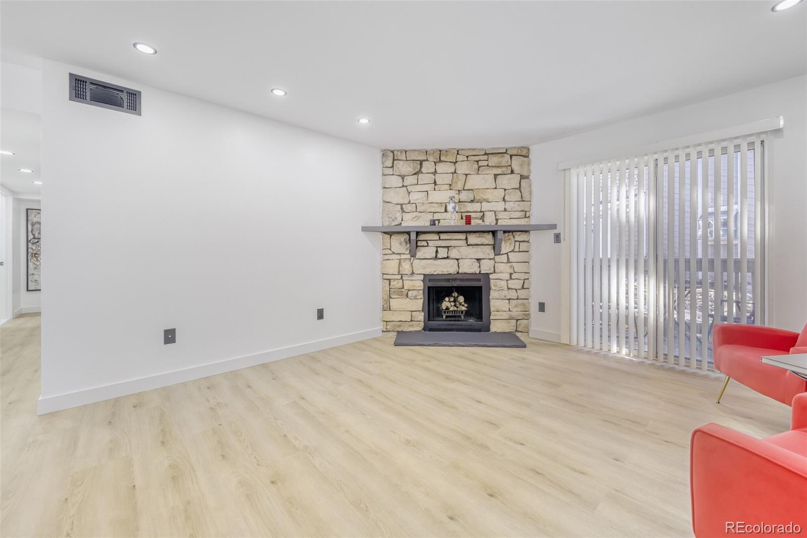 4400 South Quebec Street, Unit 106W Denver, CO 80237 - Photo 4 of 17 an empty room with floor to ceiling window and fireplace