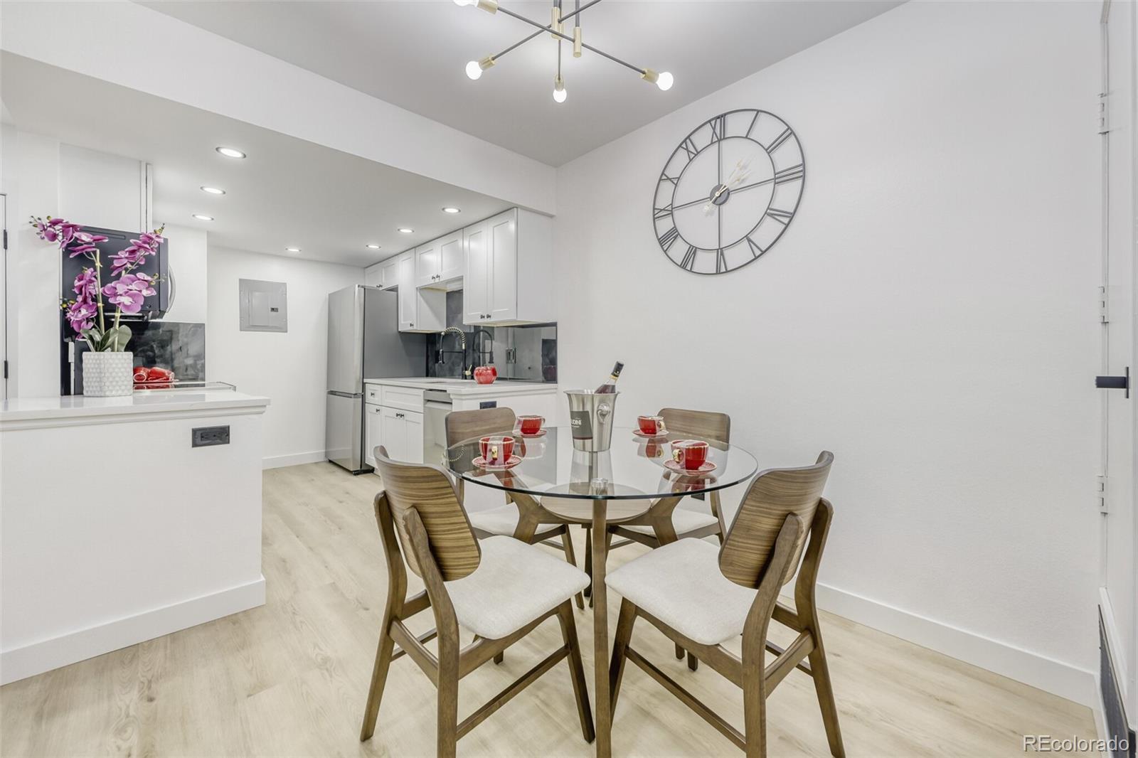 4400 South Quebec Street, Unit 106W Denver, CO 80237 - Photo 6 of 17 a view of a dining room with furniture and a chandelier