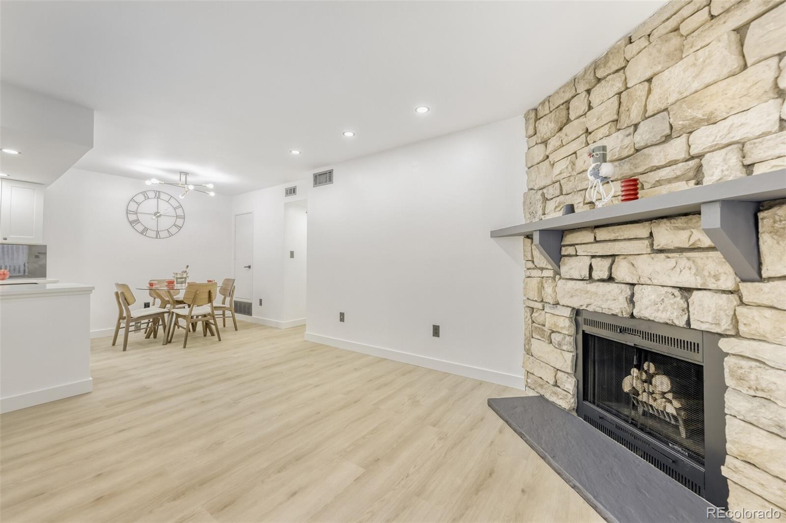 4400 South Quebec Street, Unit 106W Denver, CO 80237 - Photo 8 of 17 a livingroom with fireplace and dining room view