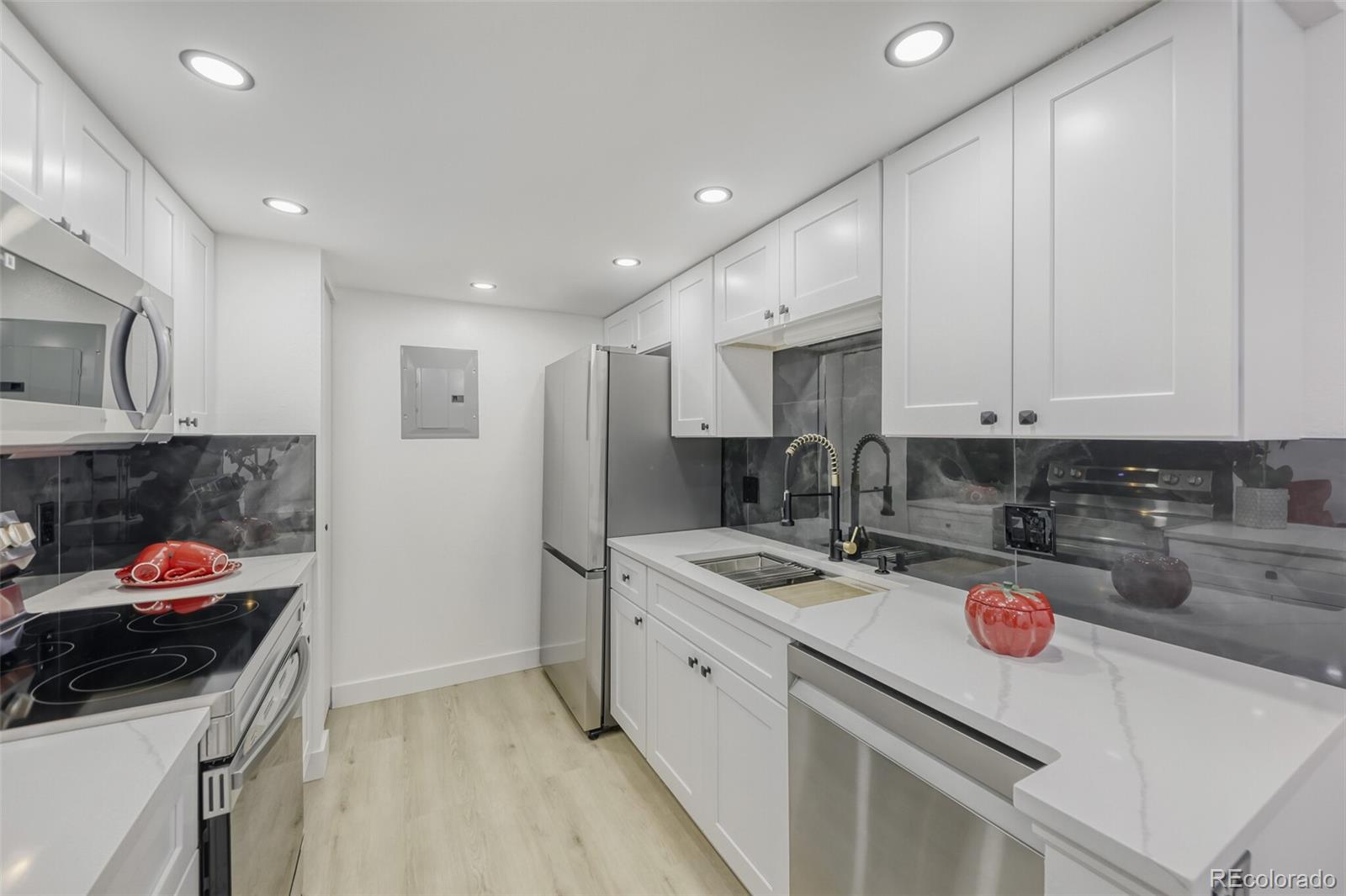 4400 South Quebec Street, Unit 106W Denver, CO 80237 - Photo 10 of 17 a kitchen with stainless steel appliances granite countertop a sink stove and refrigerator