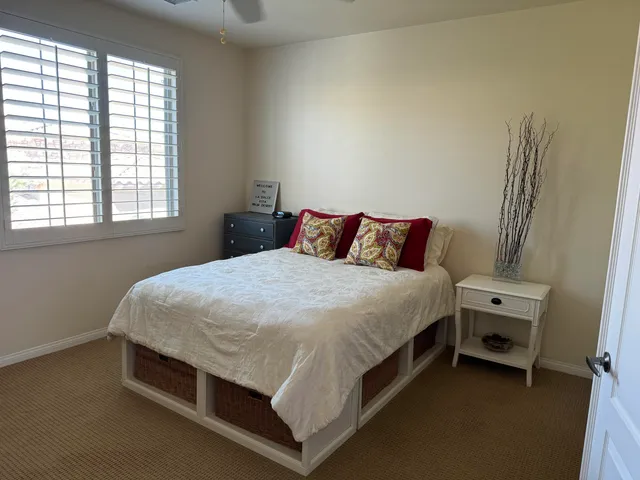 a bed sitting in a bedroom next to a window