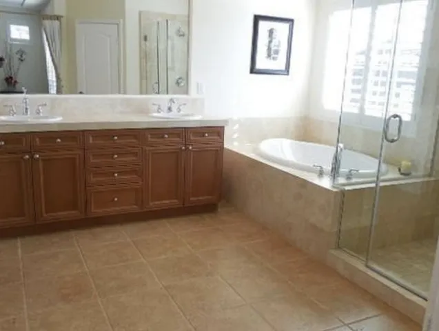 a bathroom with a granite countertop sink a mirror and a bathtub