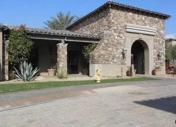 a front view of a house with a garden and plants