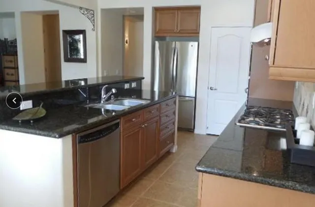 a kitchen with stainless steel appliances granite countertop a sink and a refrigerator