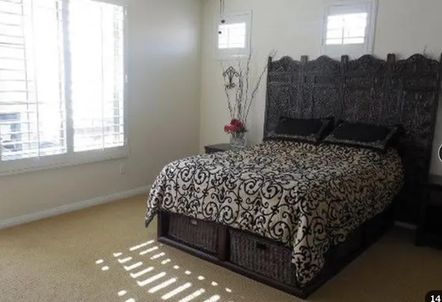 a bed sitting in a bedroom next to a window