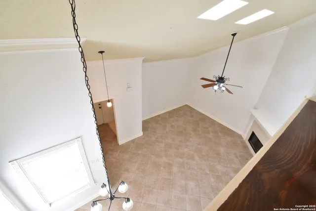 a view of a living room with furniture and a ceiling fan