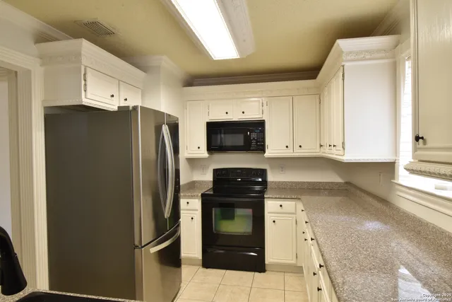 a kitchen with a refrigerator and a stove top oven