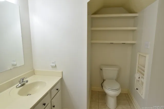 a bathroom with a toilet a sink and mirror