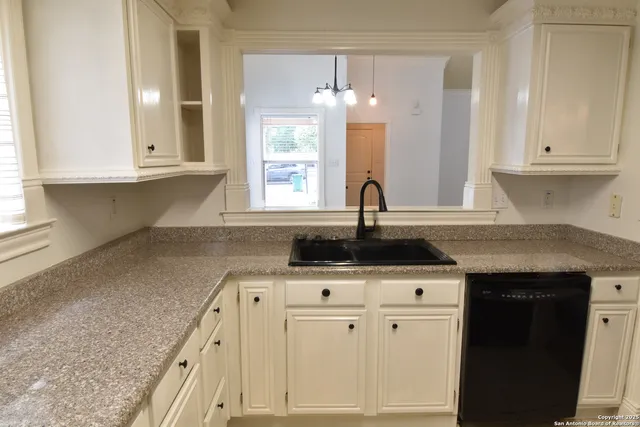 a kitchen with granite countertop a sink stainless steel appliances and cabinets