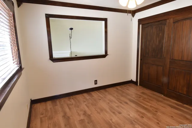 a view of a small room with wooden floor and cabinet