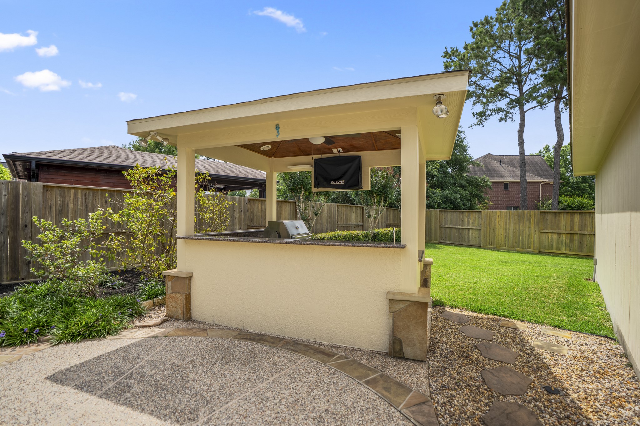 1438 Hatchmere Place Spring, TX 77379 - Photo 33 of 50 Beautifully landscaped backyard offers outdoor living at its finest with a sparkling pool featuring rock waterfall, raised spa, covered patio, detached covered outdoor kitchen.
