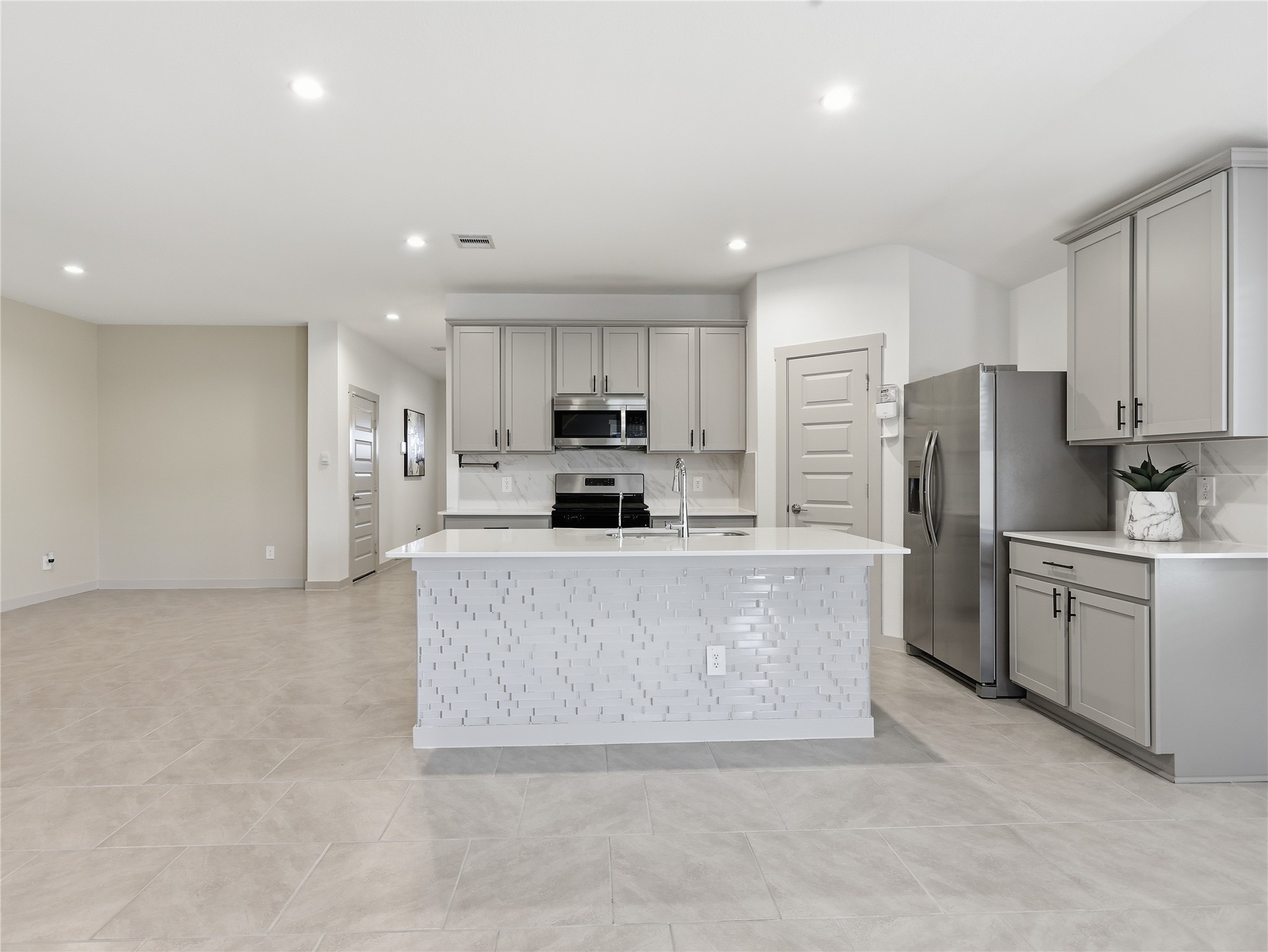 29903 Violet Sky Way Katy, TX 77494 - Photo 11 of 38 a large kitchen with a refrigerator a stove top oven a sink and dishwasher