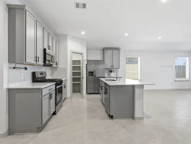 a large kitchen with stainless steel appliances lots of counter top space