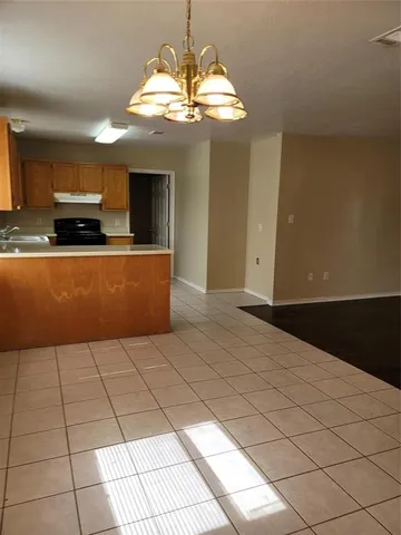 a large kitchen with kitchen island granite countertop a window and white cabinets