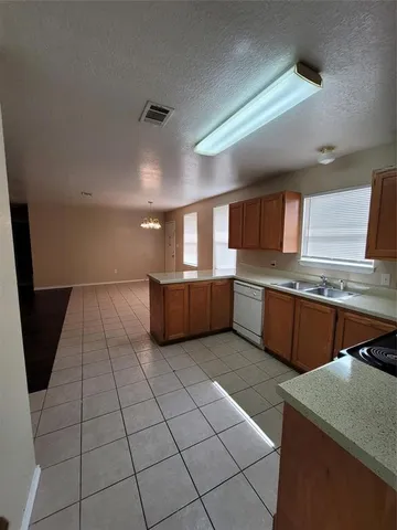 a living room with stainless steel appliances kitchen island granite countertop a refrigerator a stove a sink and a microwave