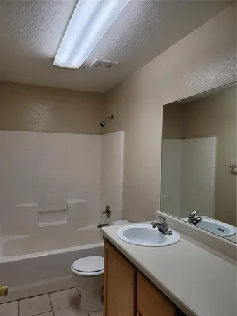 an empty room with windows and chandelier fan