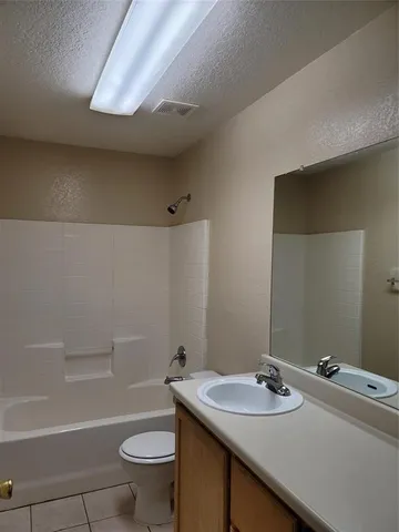 an empty room with windows and chandelier fan