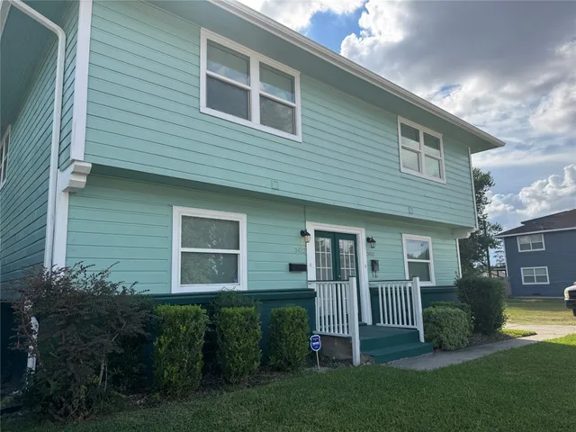 a view of a house with brick walls and a yard with plants
