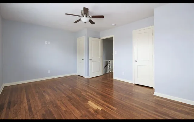 a view of an empty room with wooden floor