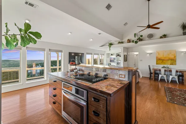 a kitchen with stainless steel appliances granite countertop a stove and a wooden floors