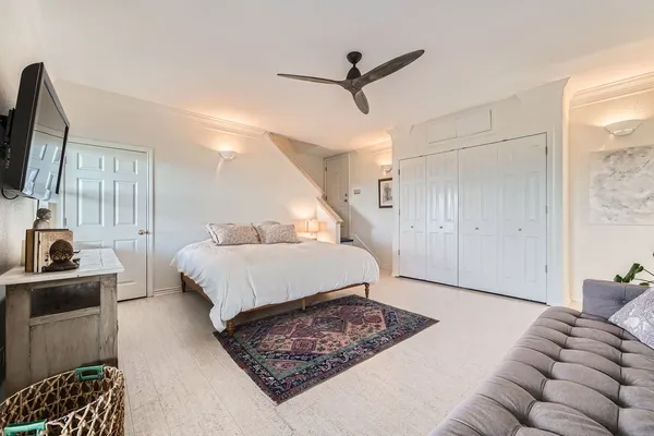 a spacious bedroom with a bed a window and dresser
