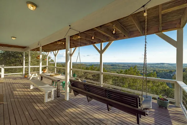 a view of a balcony with wooden floor and outdoor seating