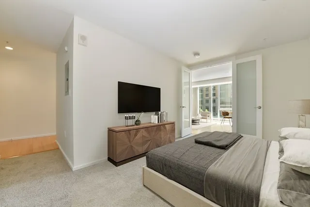 a bedroom with a flat screen tv and a bed