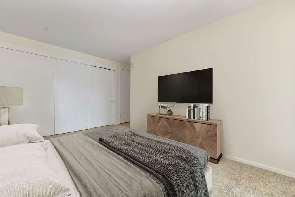 2 Earhart Street, Unit 324 Cambridge, MA 02141 - Photo 13 of 42 a bedroom with a flat screen tv and a bed