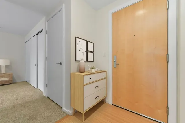 a bedroom with a bed a couch and dresser with wooden floor