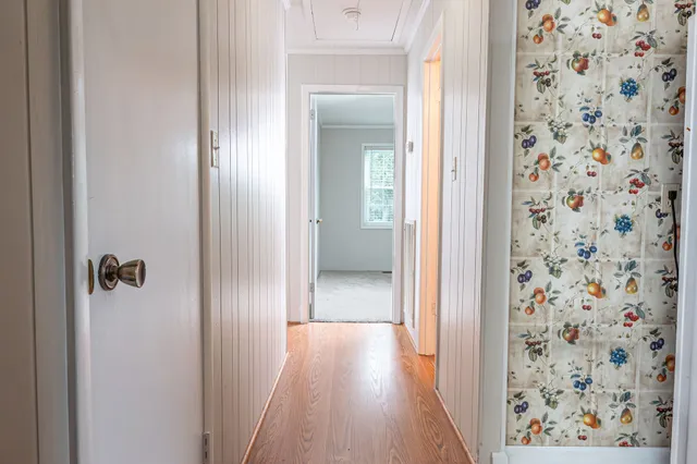 a view of a hallway with wooden floor and closet