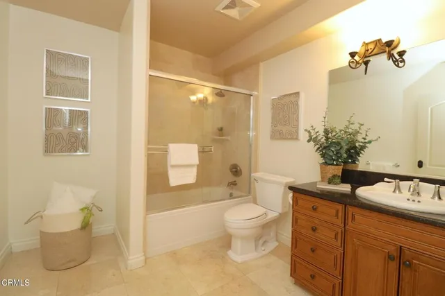 a bathroom with a granite countertop sink a toilet and shower