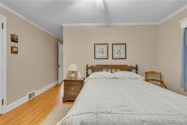 a bedroom with a bed and a painting on the wall