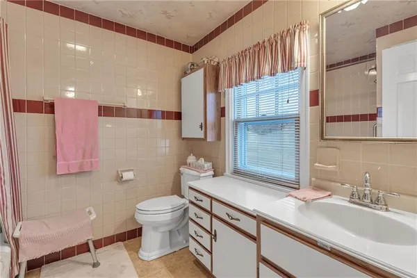 a bathroom with a sink a toilet and a large mirror