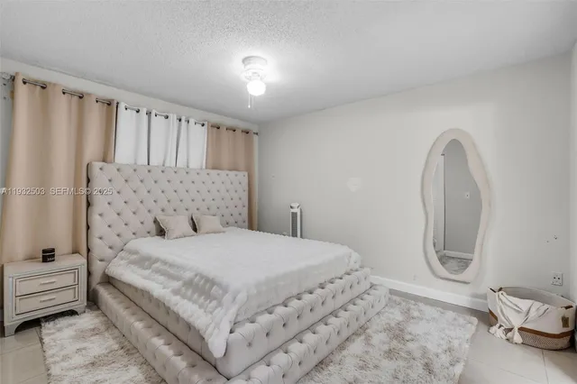 a bedroom with a bed a mirror with vanity and couches