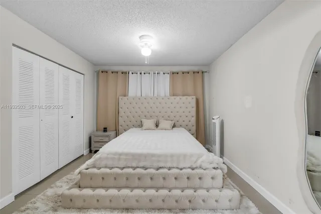 a large bed in a white room with a balcony