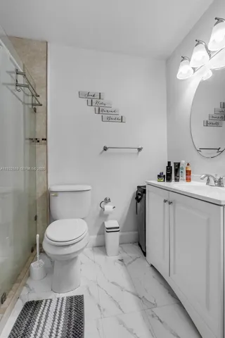 a bathroom with a sink toilet and a mirror