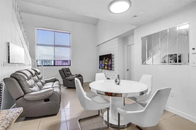 a living room with furniture a window and a dining table