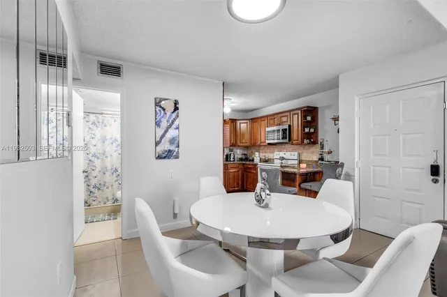 a kitchen with stainless steel appliances a dining table and chairs