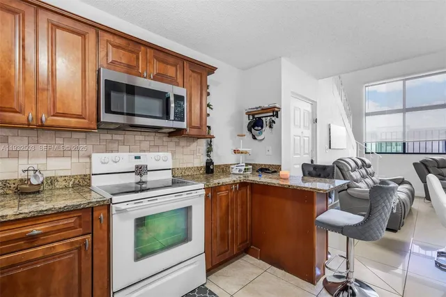 a kitchen with stainless steel appliances granite countertop a stove microwave and sink